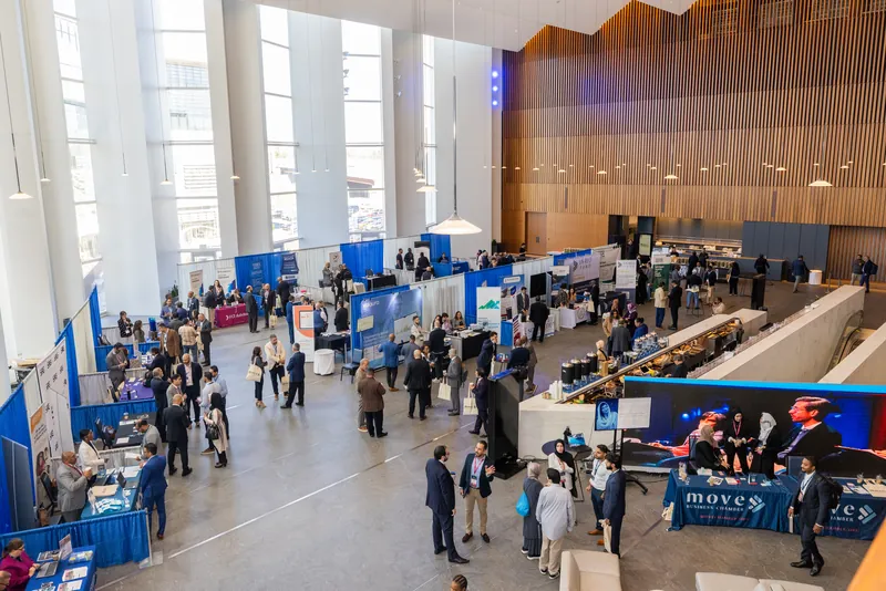 The exhibitor floor seen from above, attendees moving between booths